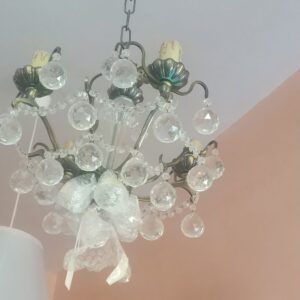 Una lampara de techo con cristales con apariencia a diamante, esta colgada en la sala de exposición del bazar Satiago Apostol, es una lampara en liquidacion de stock.